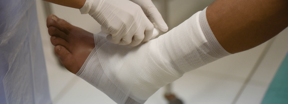 doctor administering ankle wound care